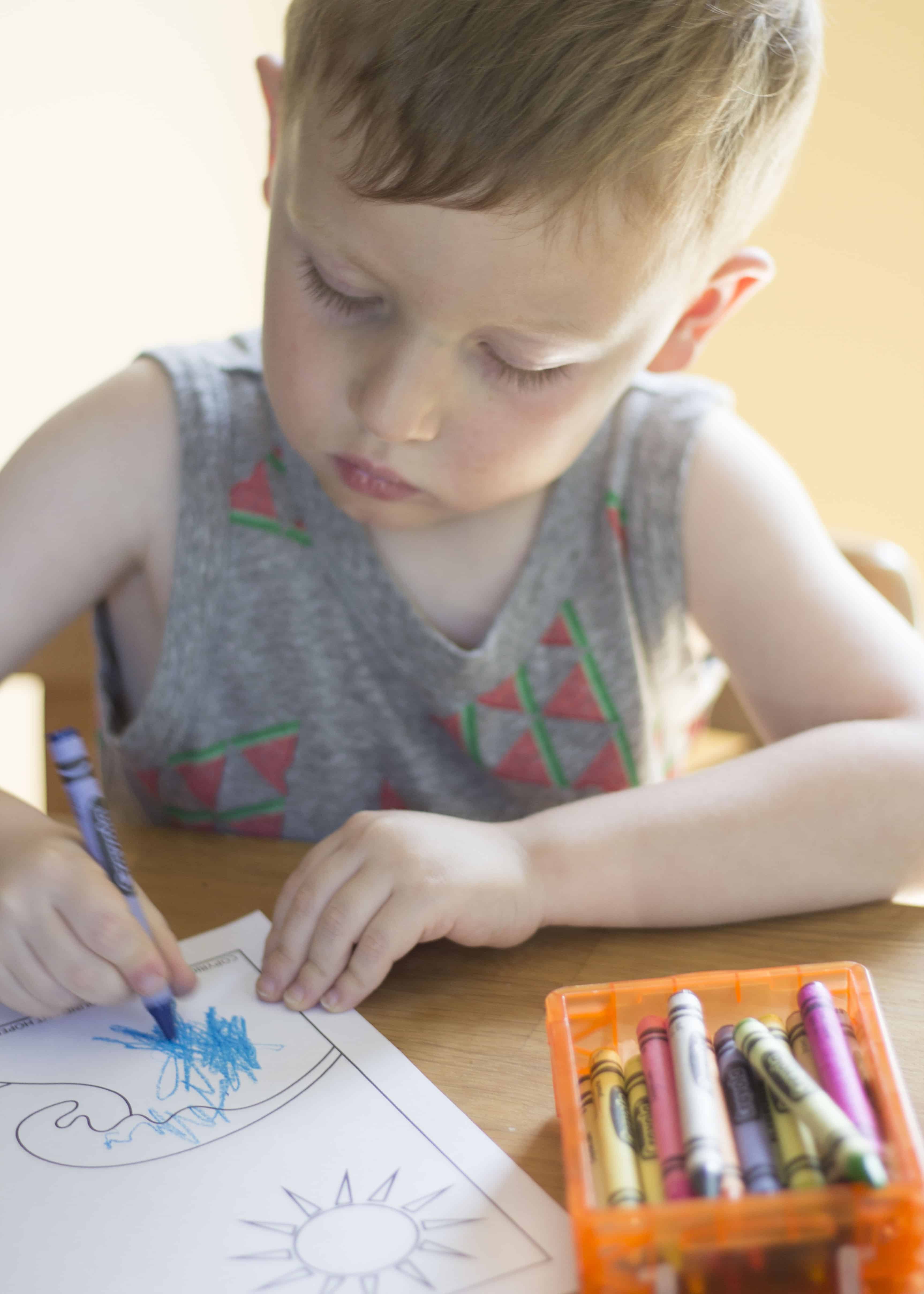 BOY COLORING WITH CRAYONS